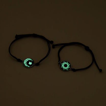 Two black bracelets with glowing green symbols on a dark background