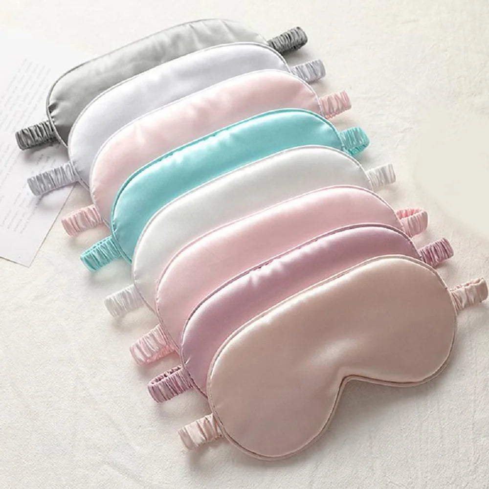 Soft pastel silk sleep masks in multiple colors neatly arranged; smooth, lightweight fabric designed for comfort and relaxation.