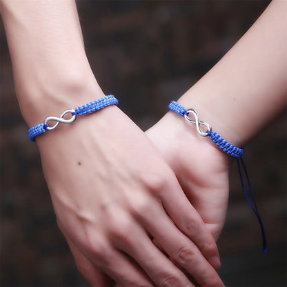 Blue braided infinity bracelets worn by couple holding hands